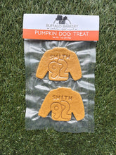 Load image into Gallery viewer, Pumpkin dog treats with 'Smith 92' engraving on a clear packaging bag, placed on grass.