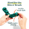 Teal dog toy with a treat being inserted held by hands against a white background